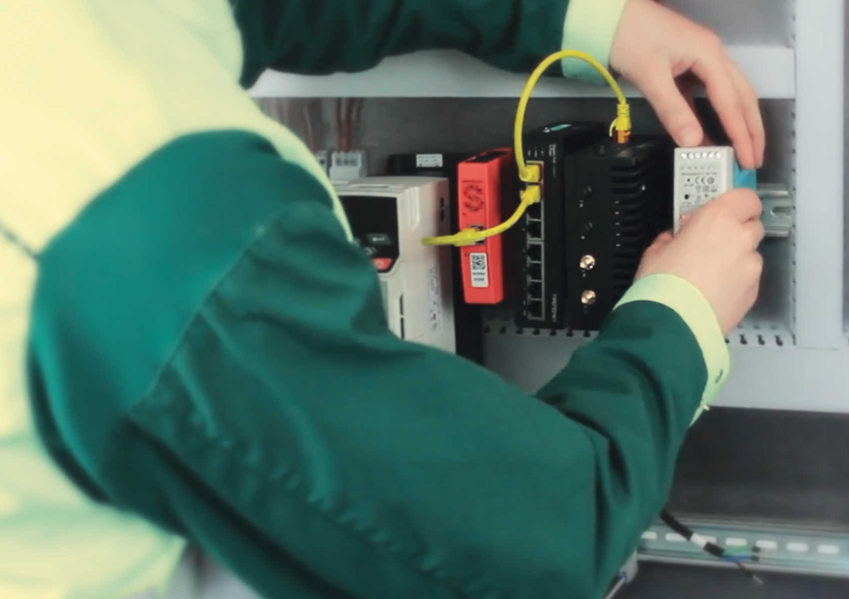 Foto eines Integrators, der einen TRENDnet Industriellen Switch und ein Netzteil in ein intelligentes Überwachungssystem für Klimaanlagen einbaut