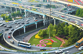 Una ilustración de una autopista de tres niveles que se asemeja a una forma de ocho, con automóviles y autobuses.