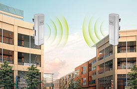 Abbildung von zwei Gebäuden mit einem 13 dBi Outdoor PoE Access Point (5 GHz) TEW-734APO, der auf jedem Gebäude angeschlossen ist, sich gegenübersteht und Signale aussendet.