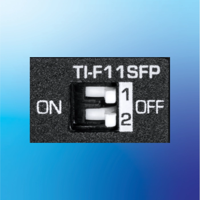 a close-up view of a DIP switch labeled TI-F11SFP. The switch has two positions, labeled 1 and 2, with the switch currently set to the 1 position. The labels ON and OFF are positioned to the left and right of the switch, respectively.